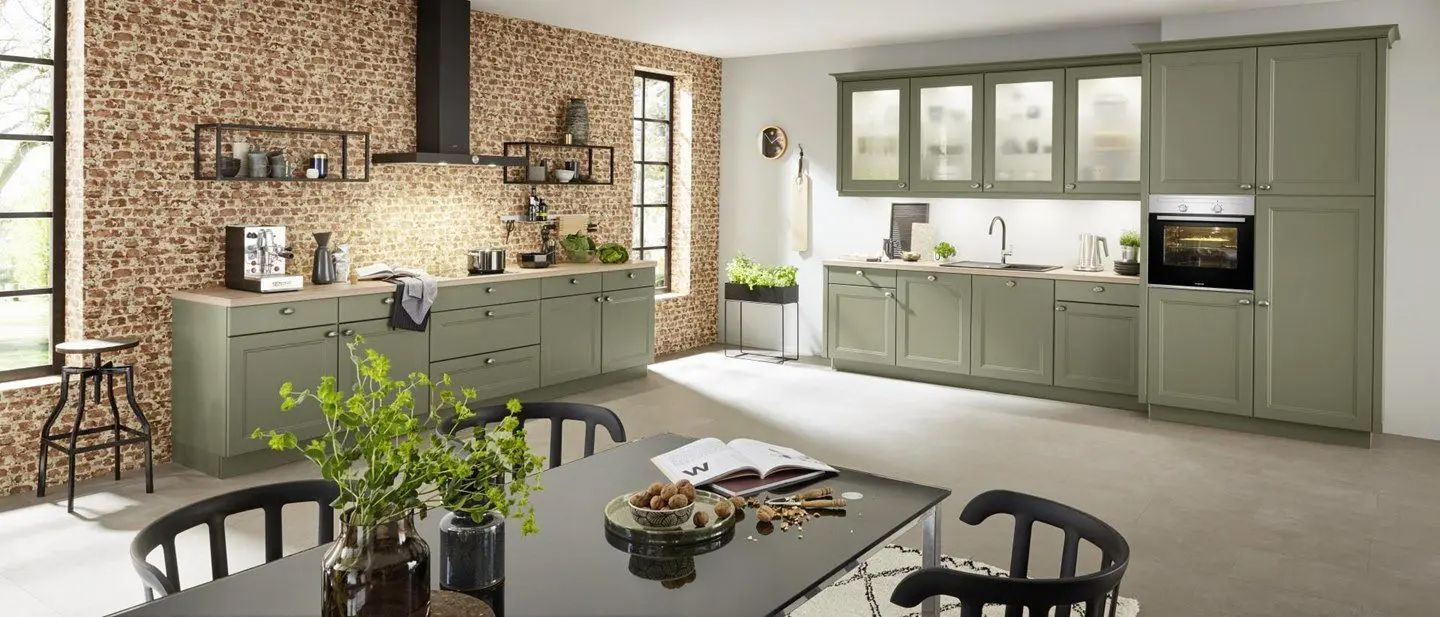 Moderne Küche mit olivgrünen Schränken und Essbereich mit dunklem Tisch